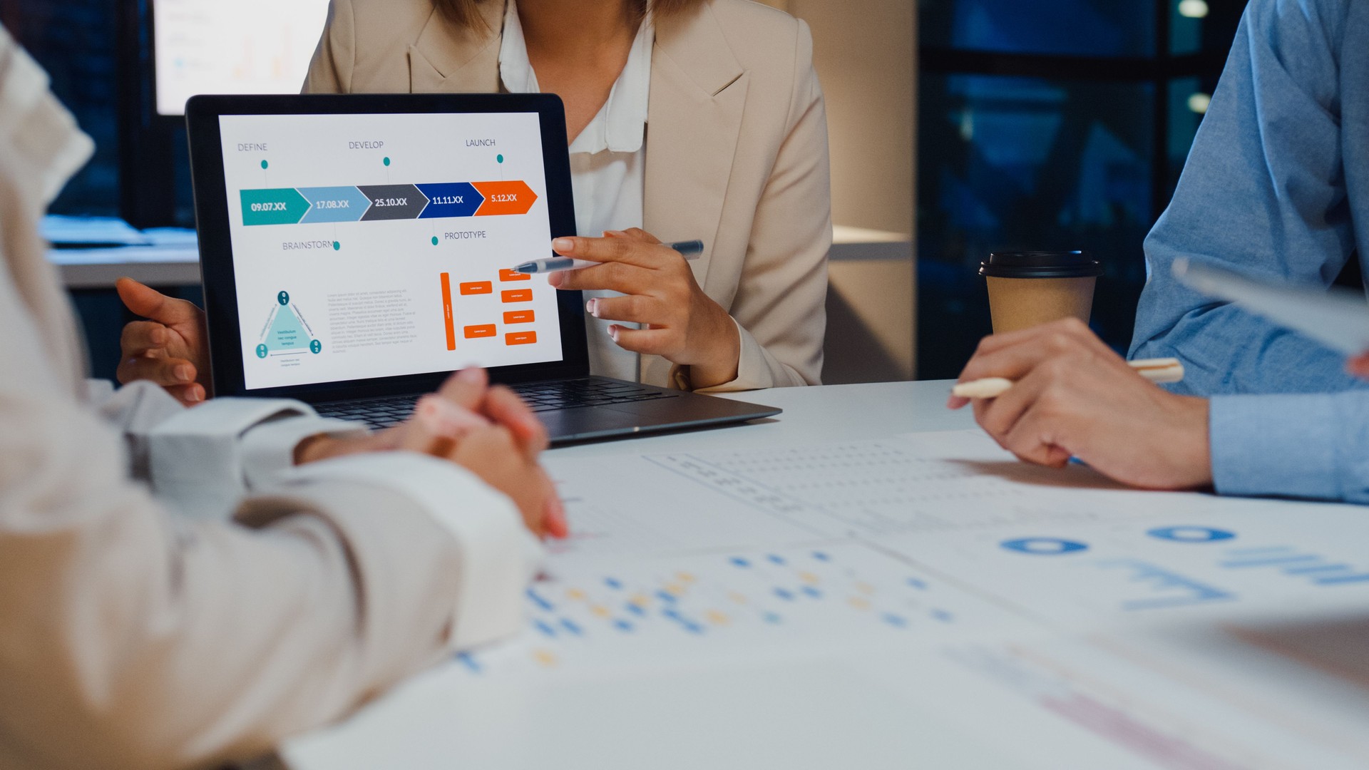 Closeup asia businesspeople meeting plan analysis statistics brainstorm and header of team hold laptop point graph chart and employee take note at home office night. Finance strategy success.